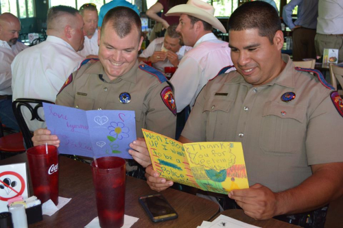 Image of two police officers reading letters from children